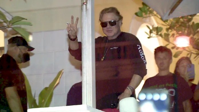 Axl Rose aparece em sacada de hotel e acena para fãs em Manaus