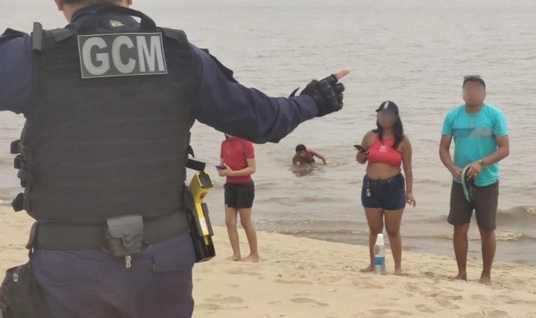 Descumprindo interdição, grupo de banhistas é orientado a sair da praia da Ponta Negra na extrema vazante do rio